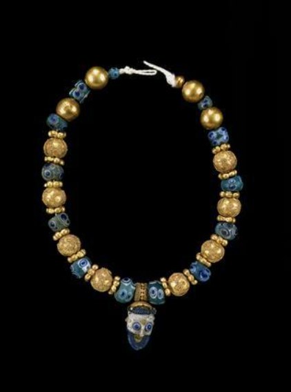 Collar etrusco/fenicio 550-450 aC compuesto de cuentas de oro y vidrio coronado con un colgante fenicio en vidrio azul. Museo británico
