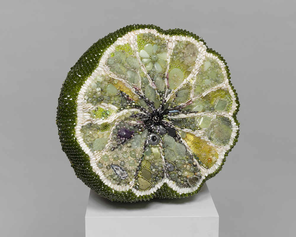 Escultura de fruta podrida con cuentas de vidrio y piedras preciosas creada por Kathleen Ryan.