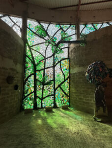 vidrio reciclado arte en vidrio dalle de verre Kitengela Hot Glass Jane Goodall homenaje artístico vitral contemporáneo vidrio sostenible escultura de vidrio arte y naturaleza reciclaje creativo arte público vidrio africano instalación artística Cultural Heritage Arusha diseño sostenible arte ecológico bosque de vidrio África Oriental